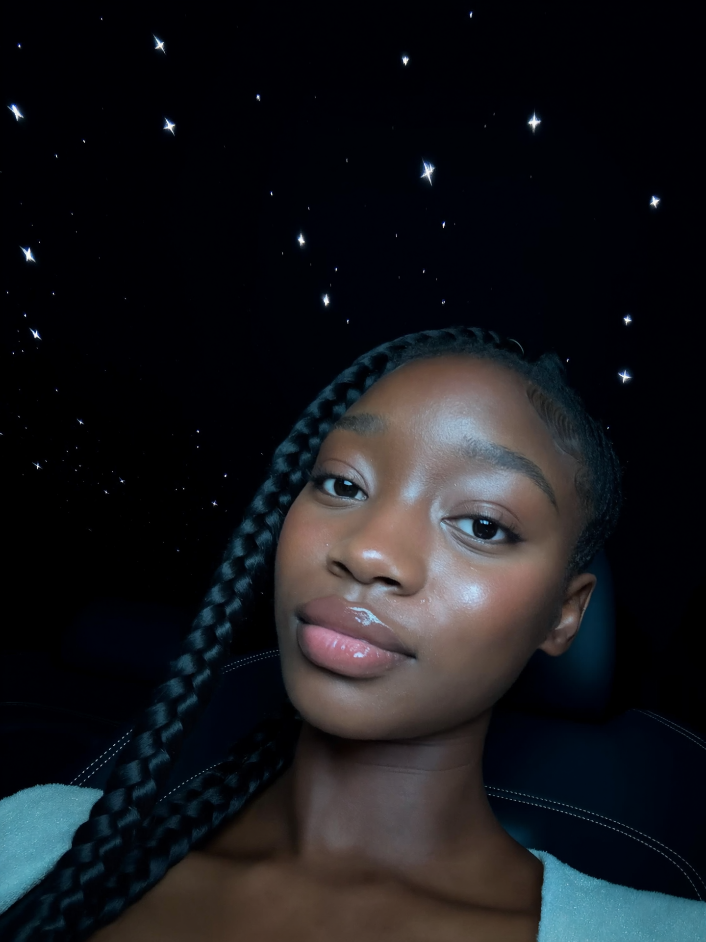 Low-light close-up AI portrait of a woman with long braided hair against a dark background