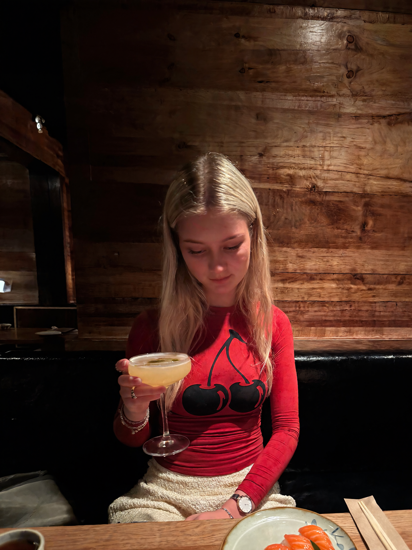 AI portrait of a blonde woman in a red outfit seated in a candlelit restaurant