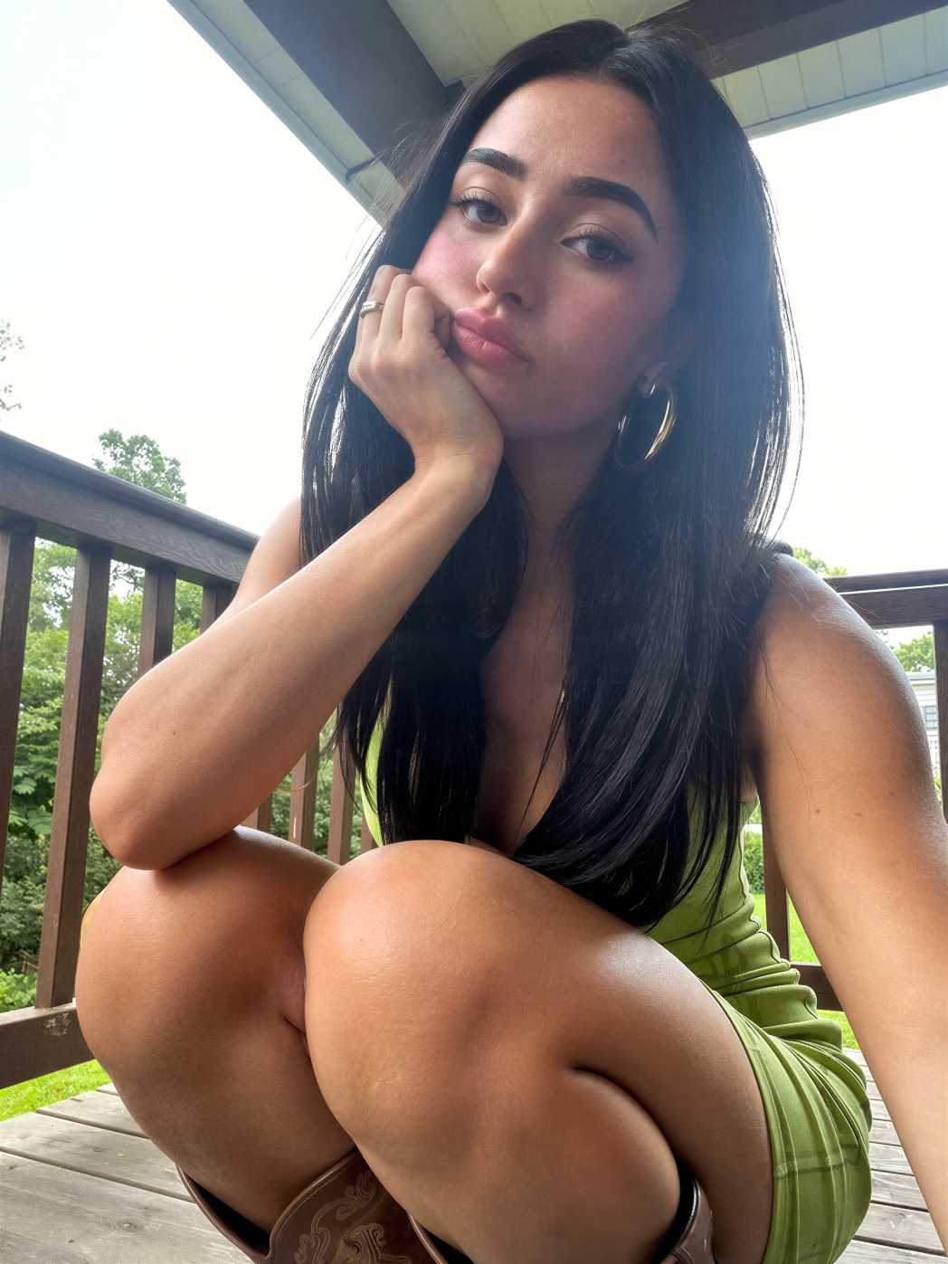 Daylight AI portrait of a dark-haired woman seated casually on an outdoor balcony