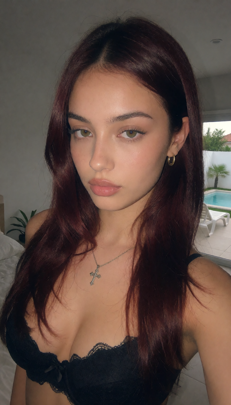 Girl with long dark hair wearing a black lace-trimmed top indoors near a bright poolside window