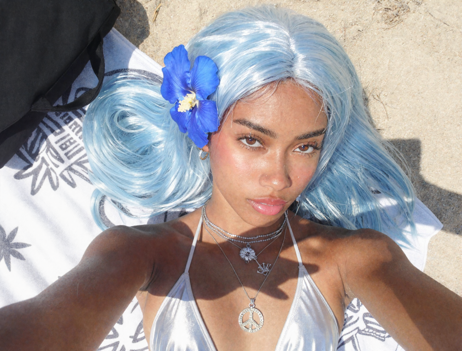 Outdoor AI selfie of a woman with pale blue hair, a blue flower, and silver jewelry in bright sun